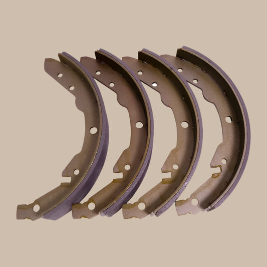 Set of four brown brake shoes on a white background