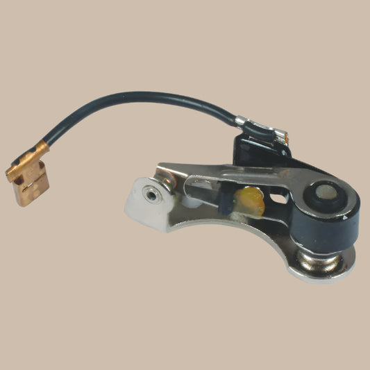 Mechanical component - ignition points, with a black wire on a beige background
