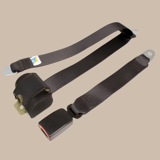 Two black seat belts with metal hardware on a beige background